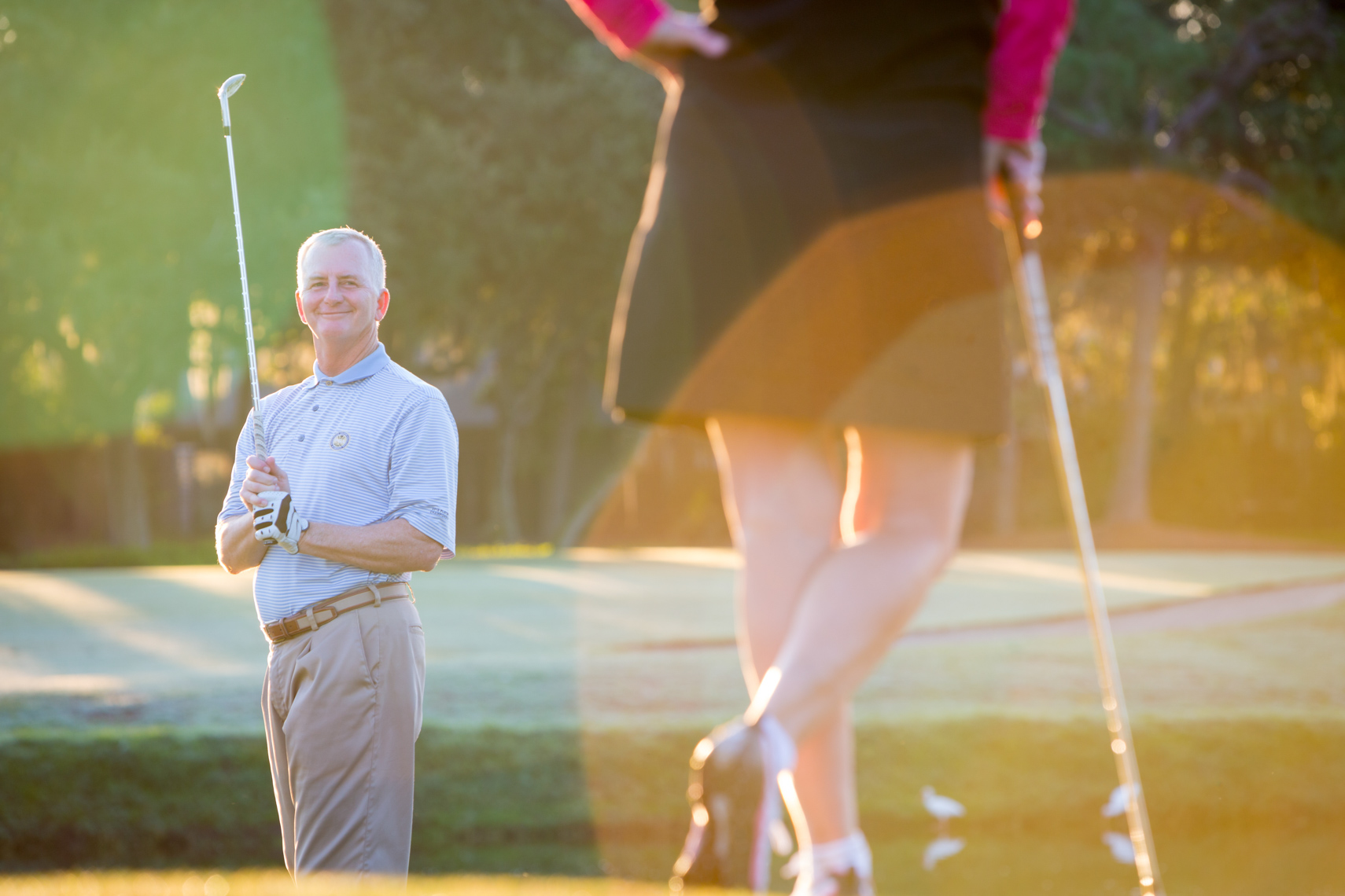 Senior man golfing and looking at woman, shot by Steve Widoff