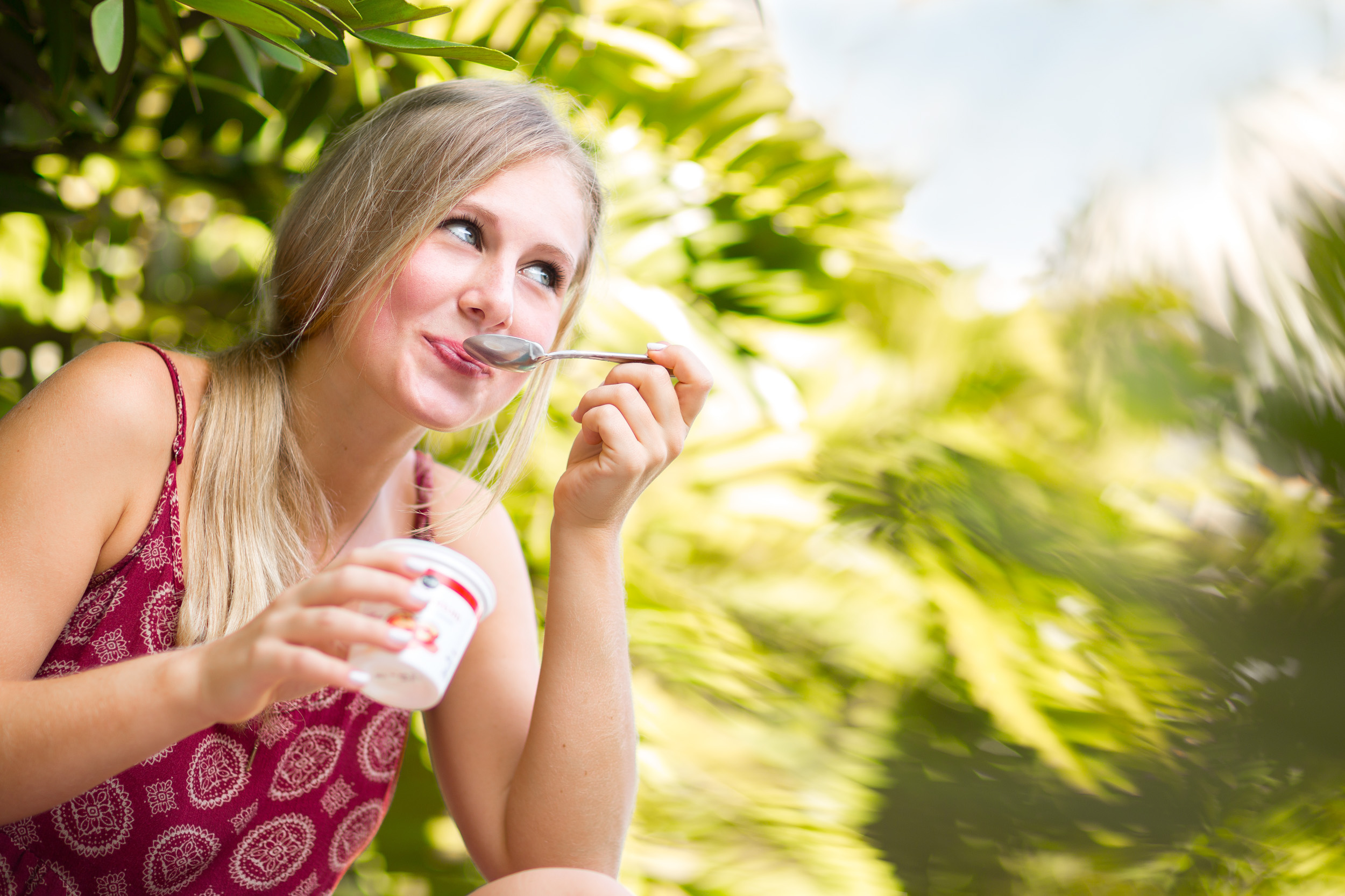 Young woman eating yogurt, photographed by commercial photographer Steve Widoff