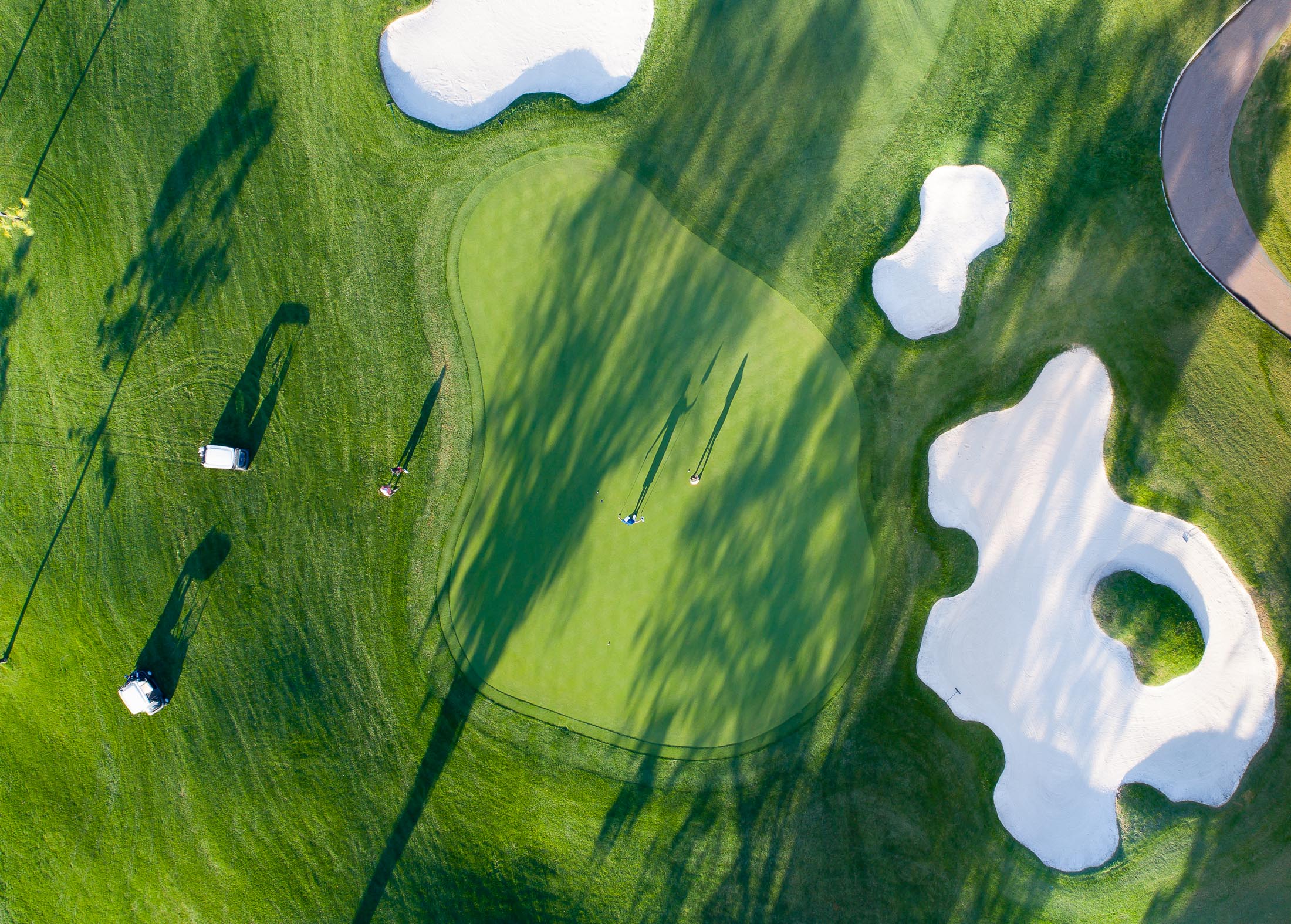 aerial of golf course hole and players